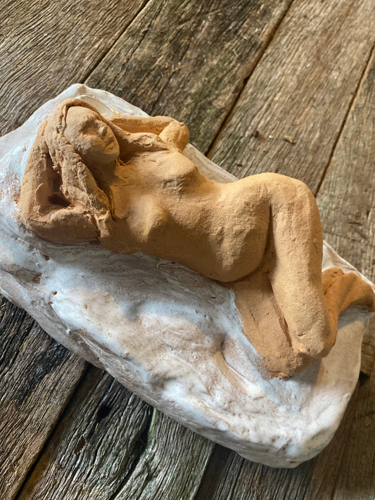 clay figure reclining on base